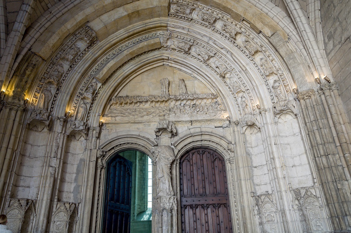 Arched stone entryway with carvings and wooden doors