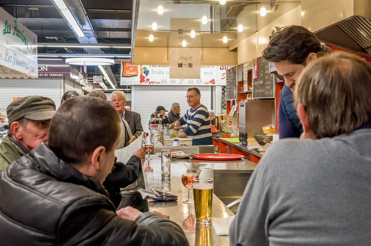 People at a lunch counter drinking beer and wine