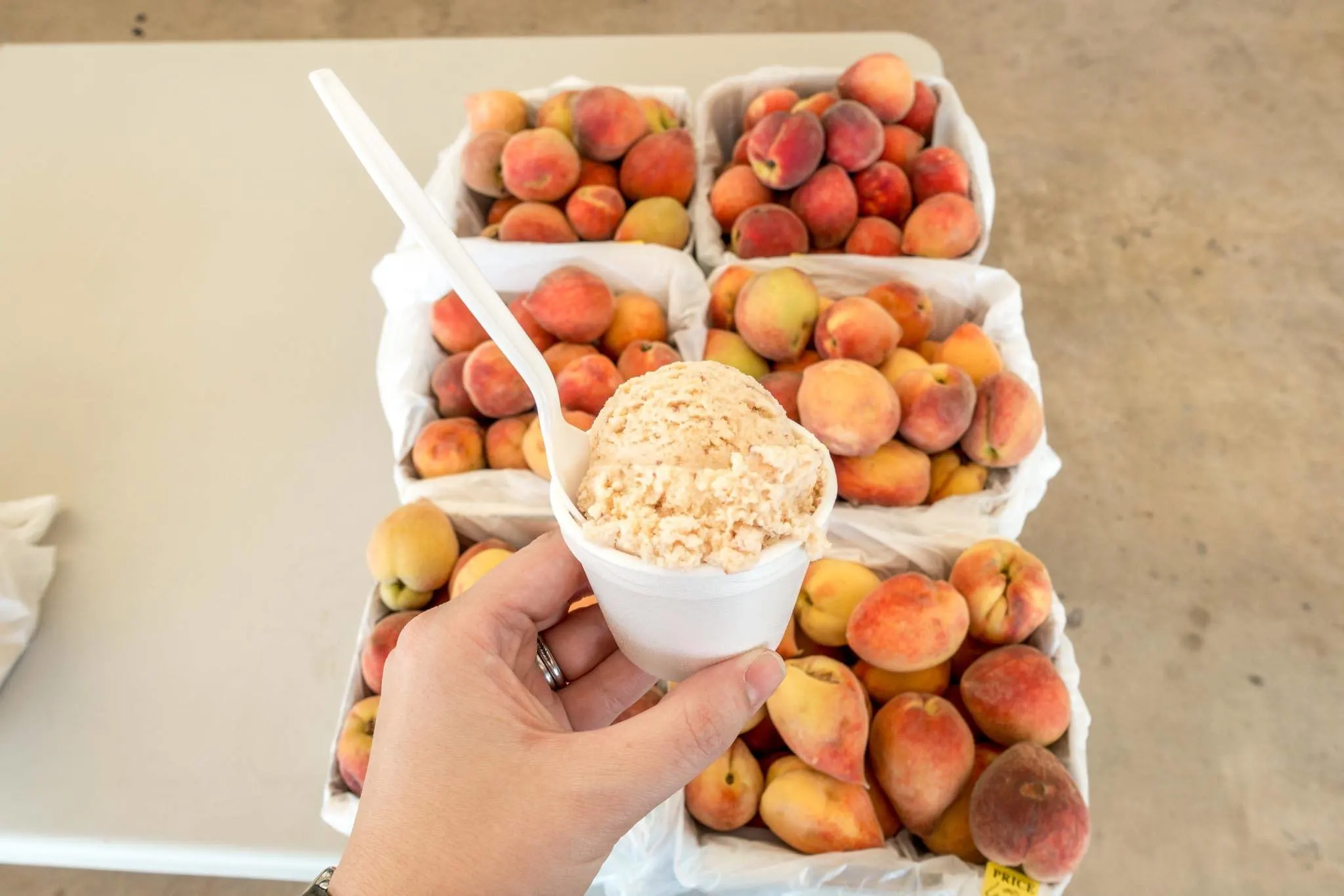 Fresh peaches on a table and peach ice cream in a cup.