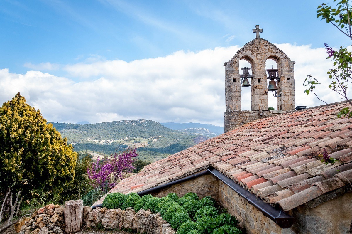 Church bells and tiled roof  overlooking a hilly landscape
