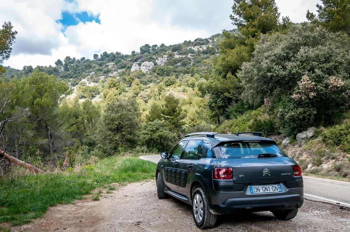 Car on road in France surrounded by hills