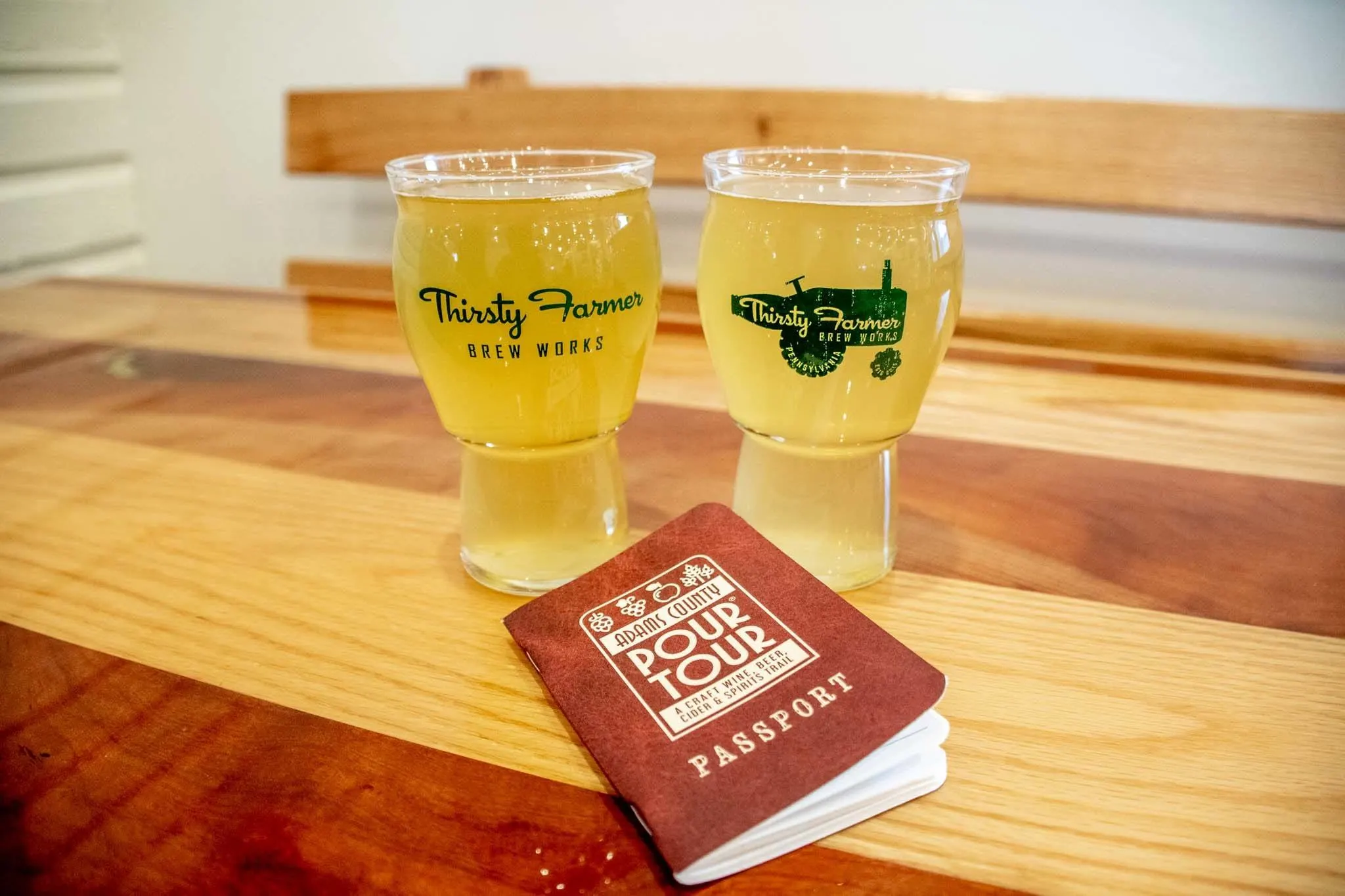 Full beer glasses and a "Pour Tour" booklet on table at the Thirsty Farmer.