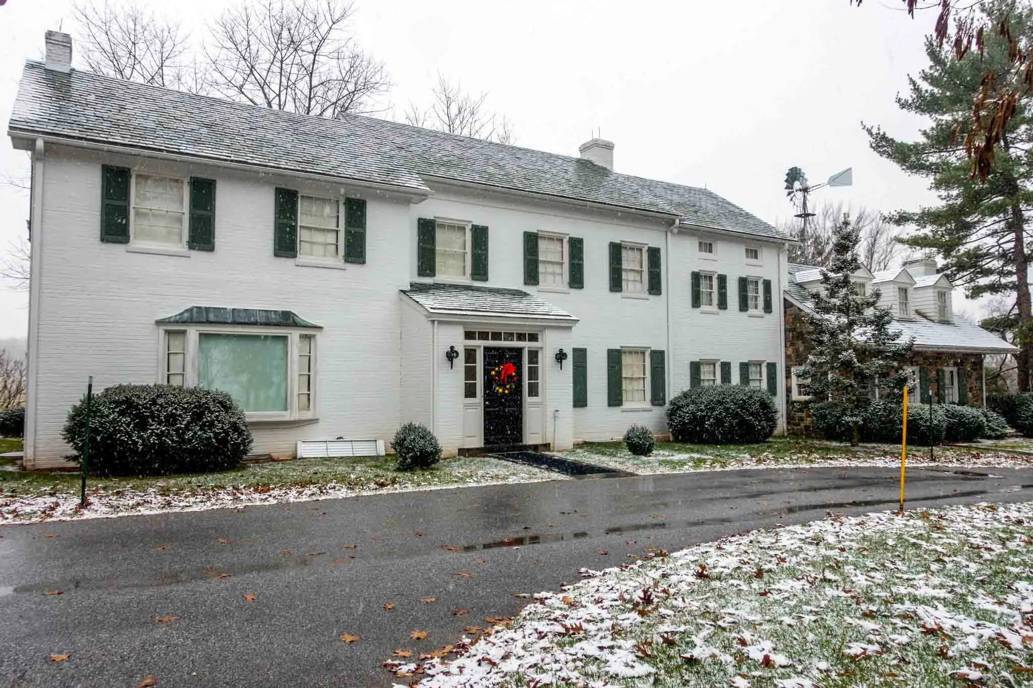 Exterior of a white brick house and snow on the ground 