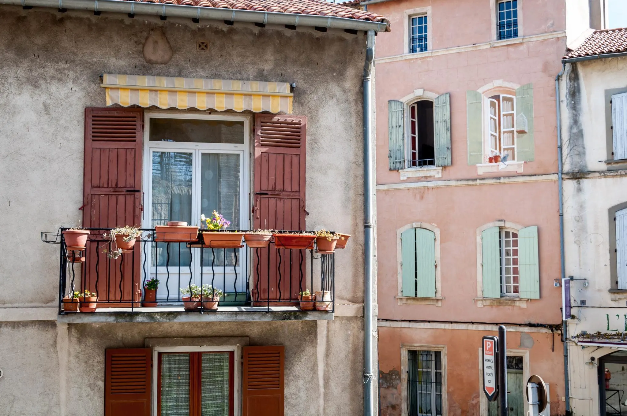 Window boxes and colorful window shutters in Arles, France