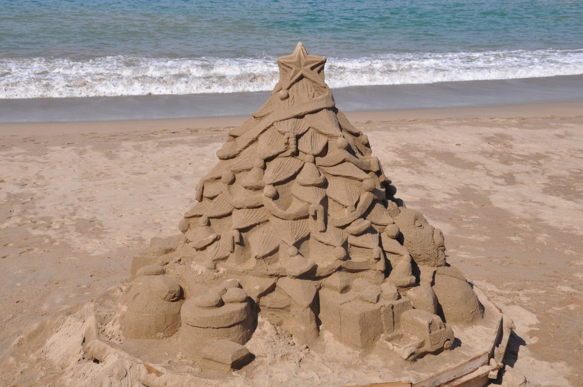 Sand sculpture of a Christmas tree on the beach in Mexico