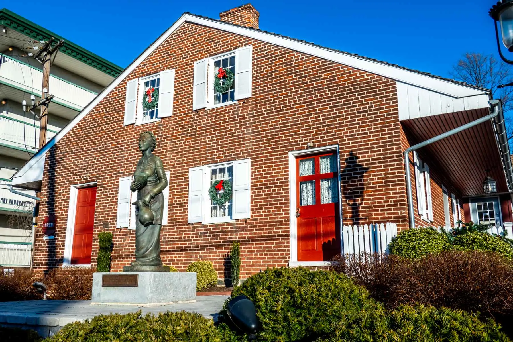 Brick house with a statue of Jennie Wade in front.