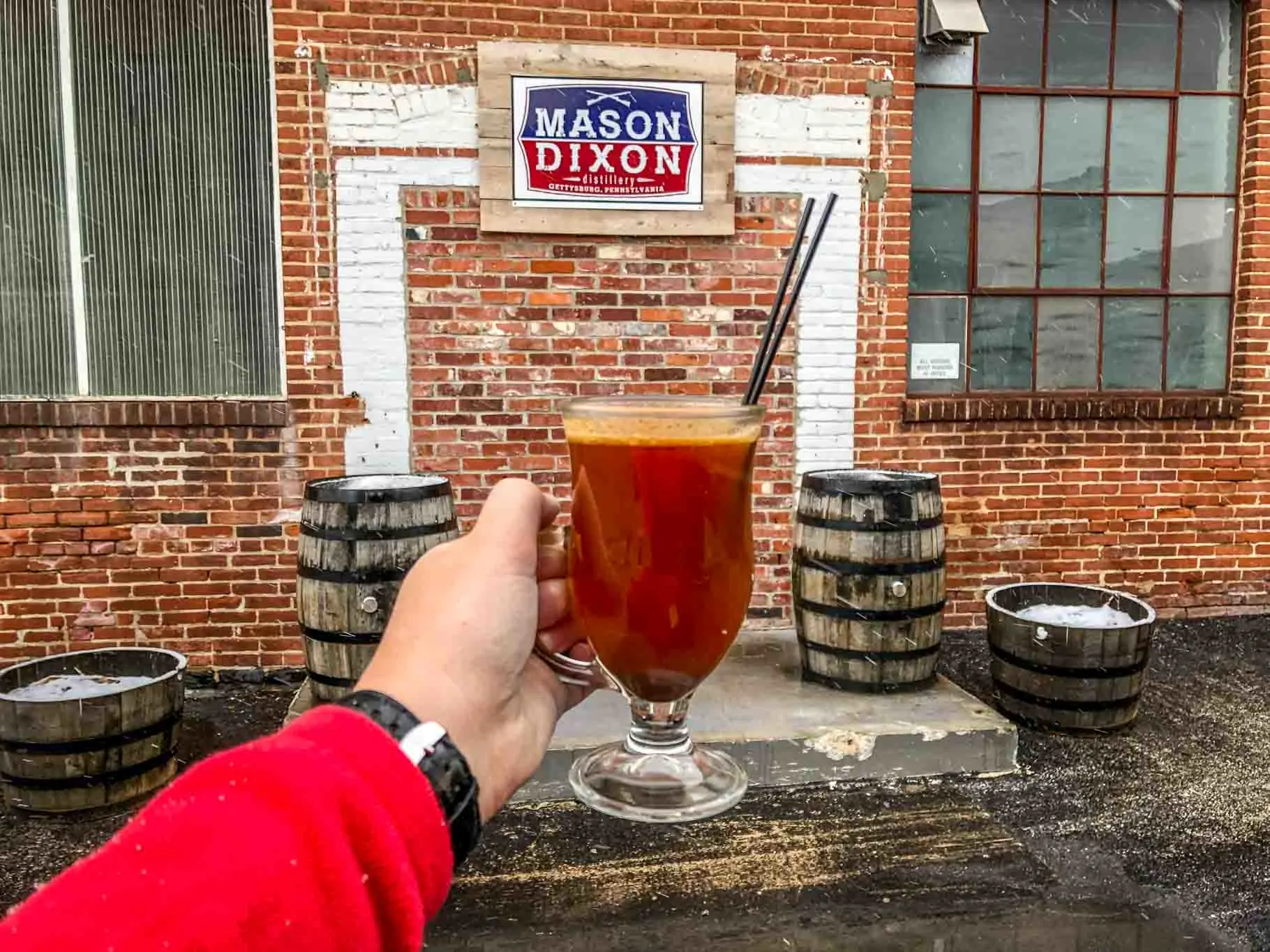 Cocktail in front of sign for Mason Dixon Distillery in Gettysburg, Pennsylvania.