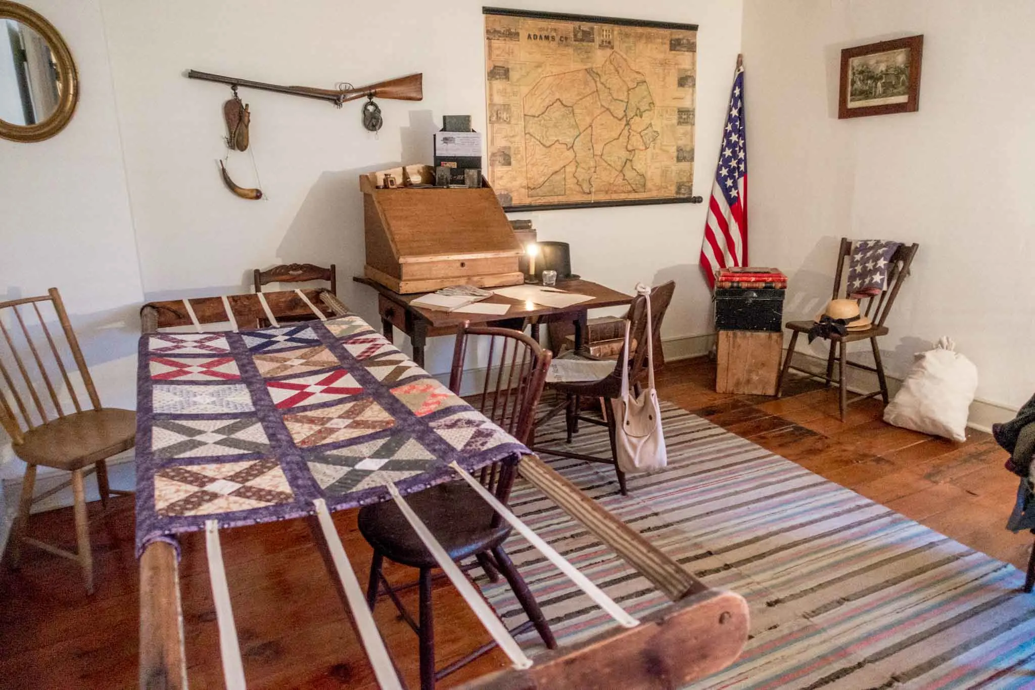 Civil War-era quilting room with desk and map. 