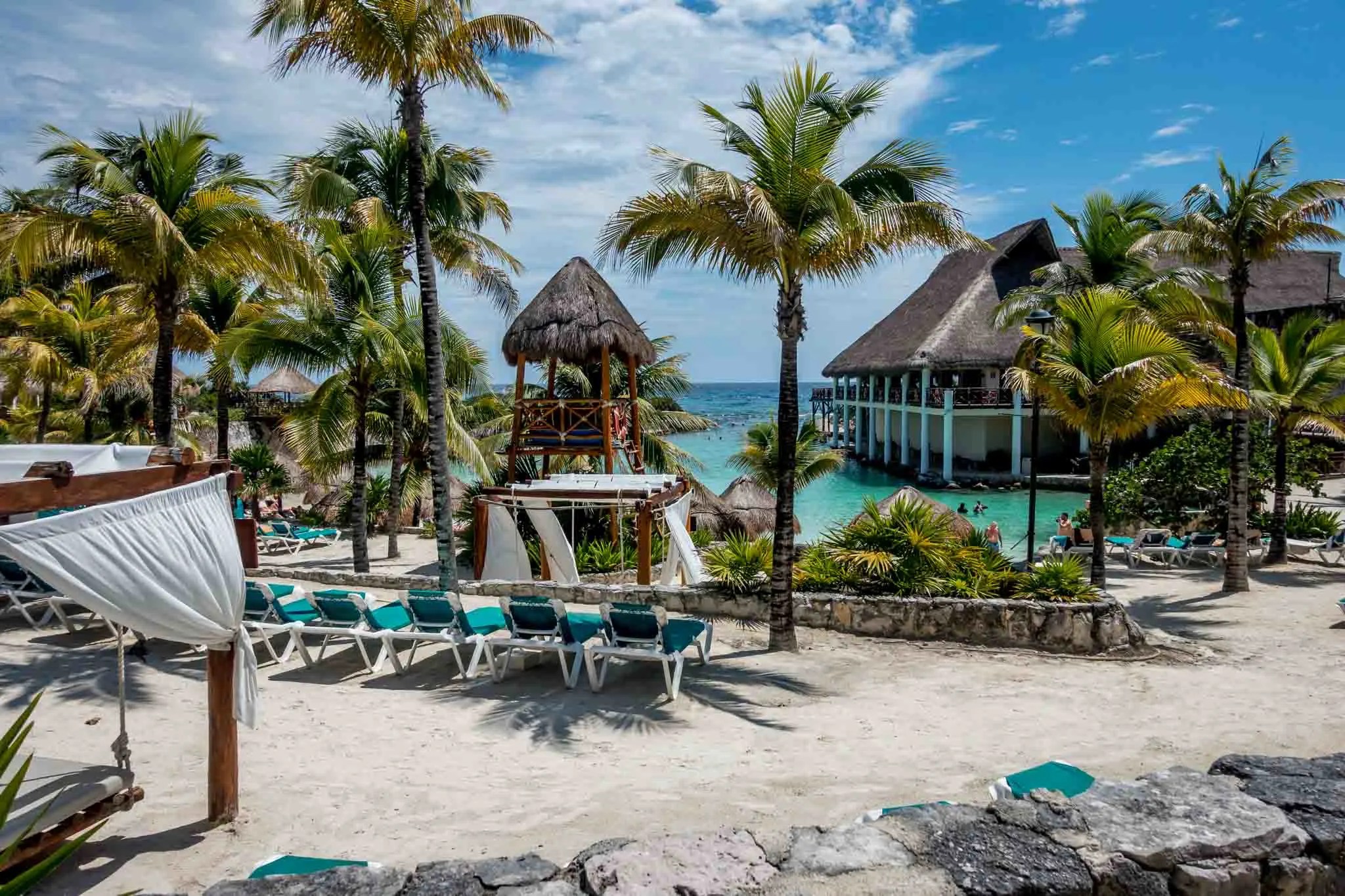 Sitting area by the ocean surrounded by palm trees