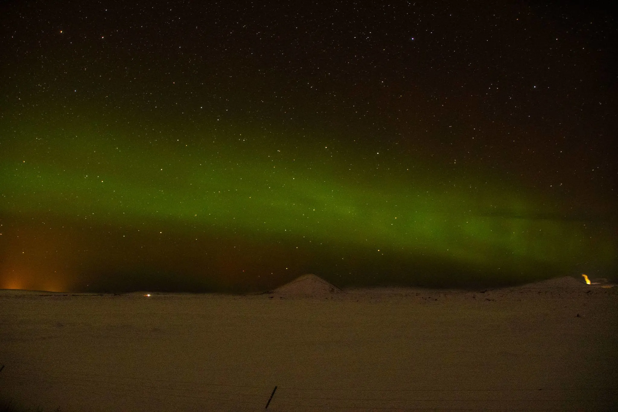 Green northern lights across the night sky in Iceland.