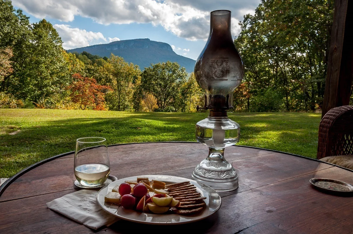 Wine and cheese on a table with a view of fall foliage