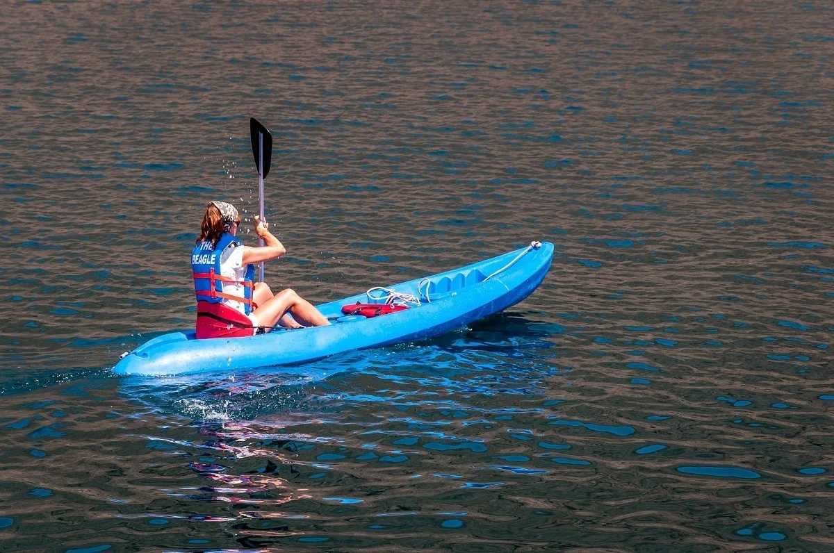 A woman in a blue sea kayak during a Galapagos cruise