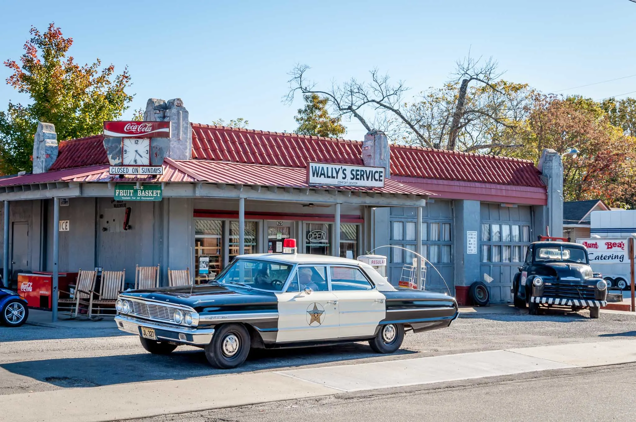 Old fashioned police car in front of Wally's Service station