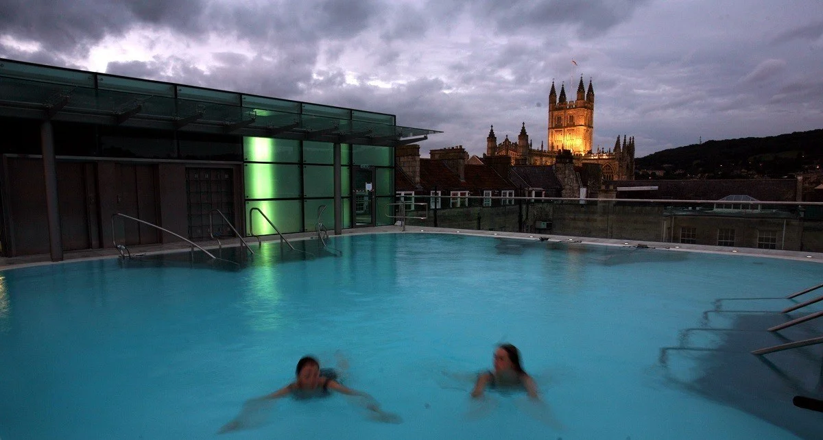 Women swimming in the rooftop pool at twilight