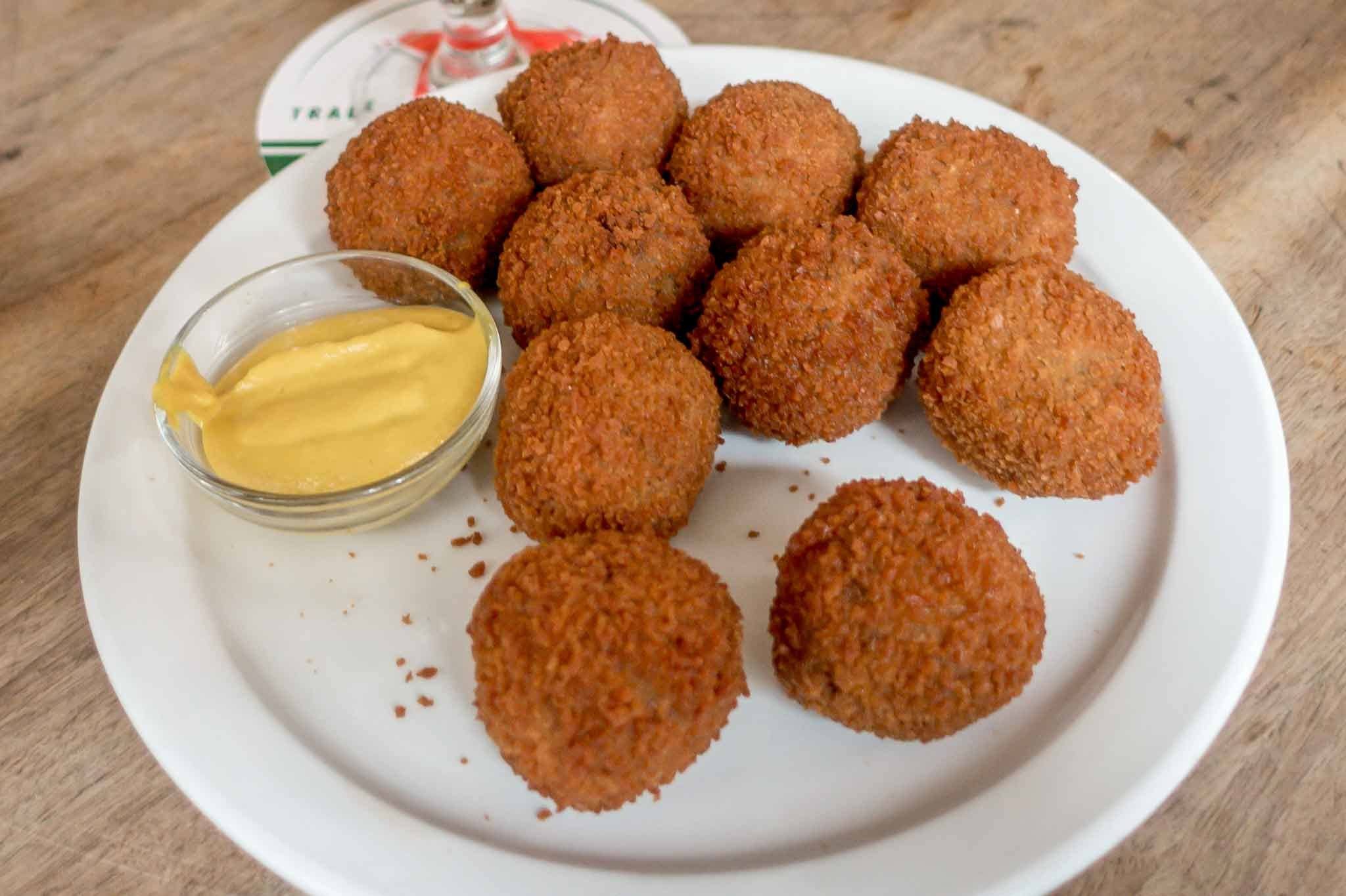 Fried balls of bitterballen with mustard on a plate