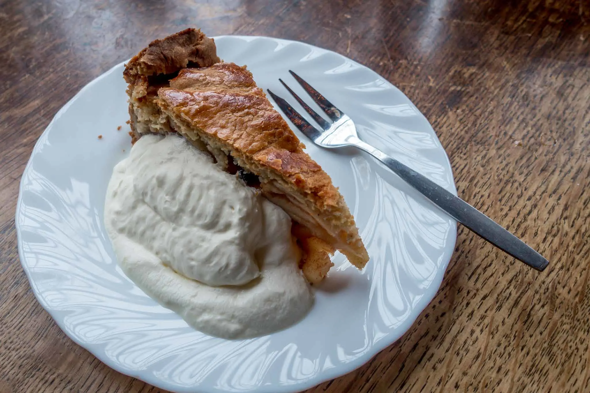 Dutch apple pie with whipped cream and fork