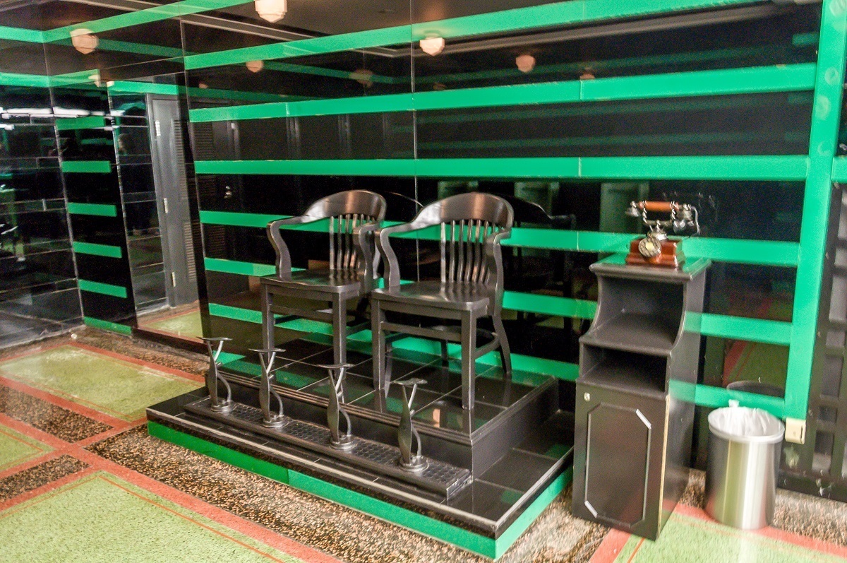 Shoe shine chairs in the famous green and black tiled men's bathroom