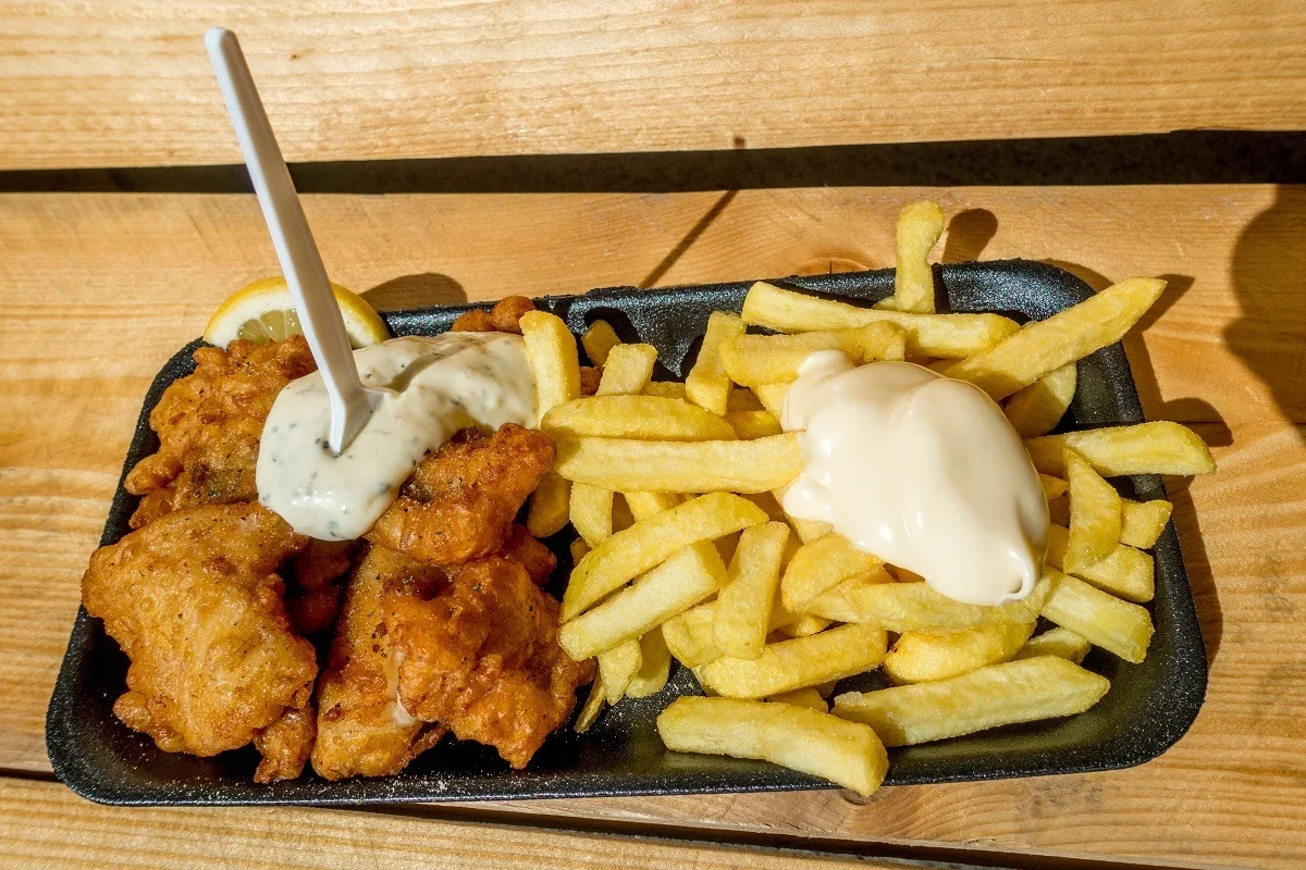 Fried cod with tartar sauce and French fries on a plate