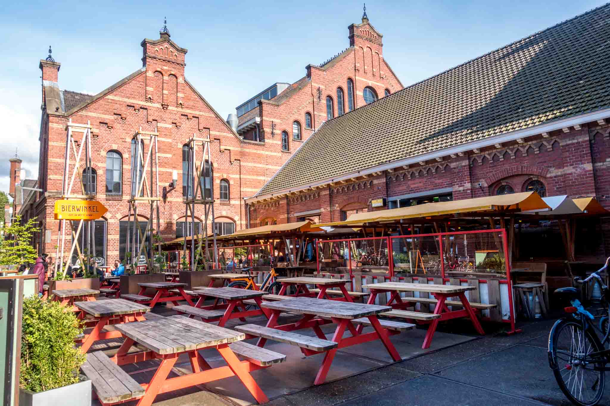 Outdoor seating at a brewery in a red brick building.