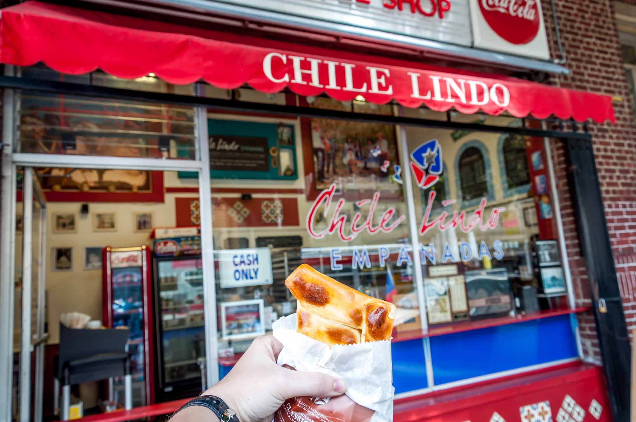 Chilean empanada in front of Chile Lindo storefront.