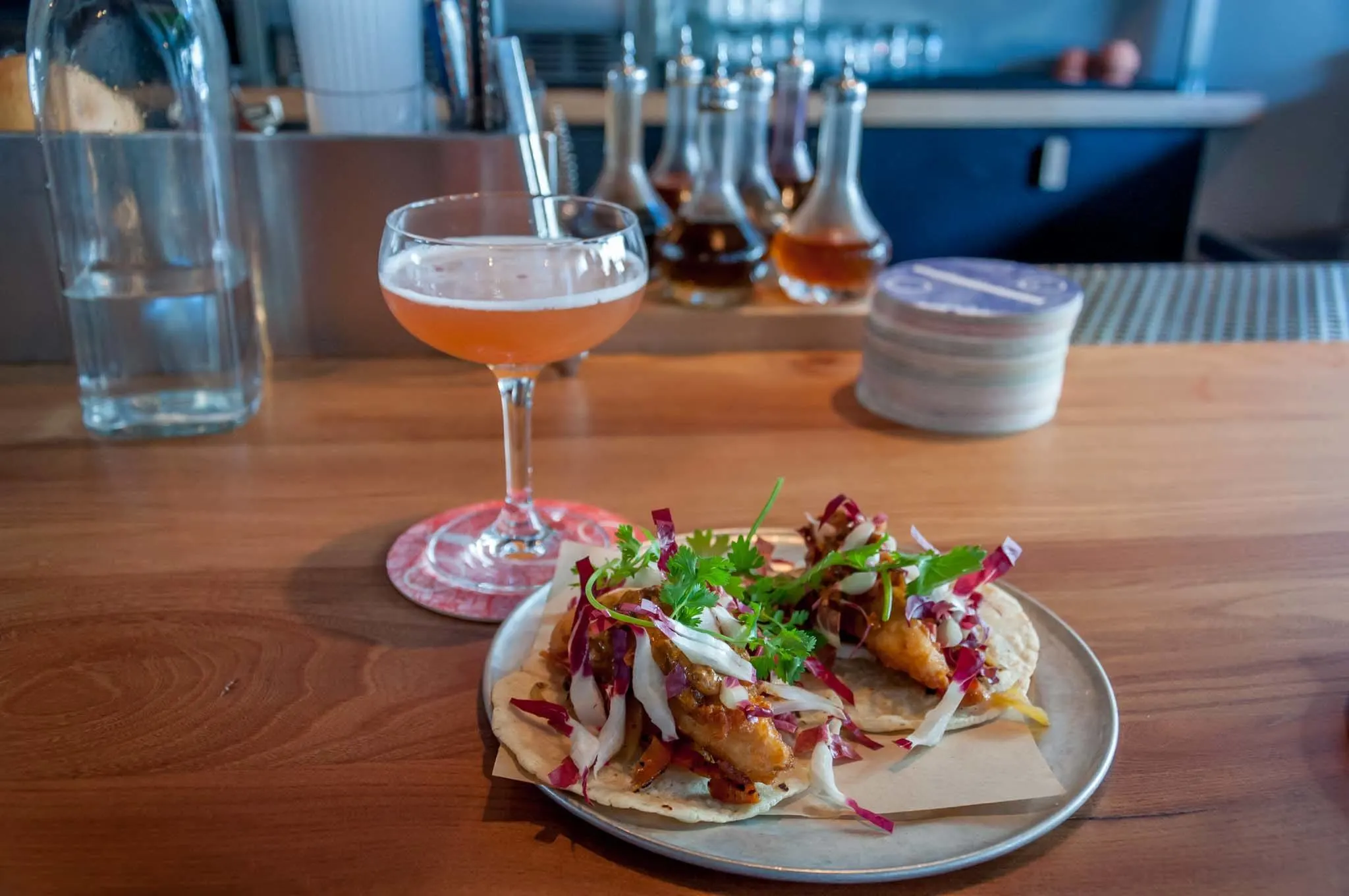 Cocktail and fish tacos on a table