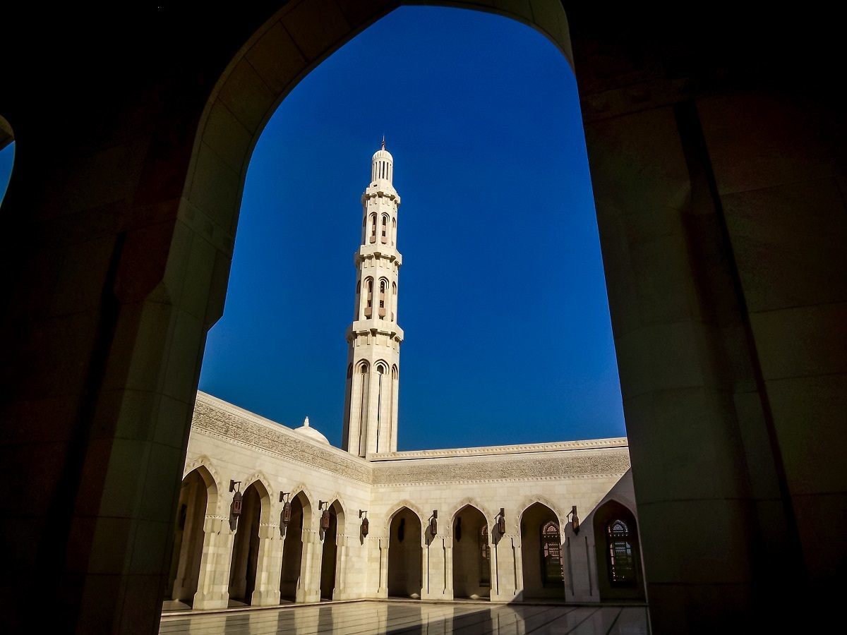 Minaret of the Grand Mosque in Muscat seen through an arch