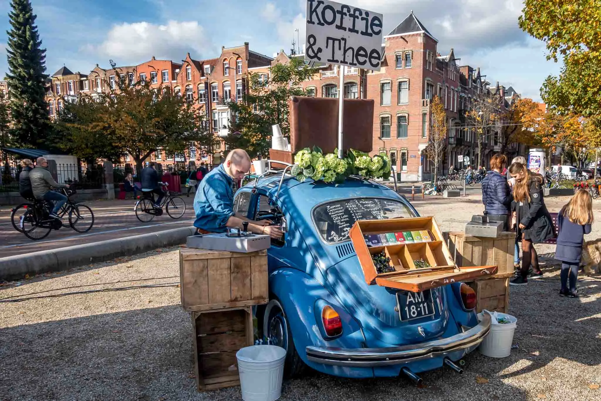 Man serving coffee from a VW bug. 