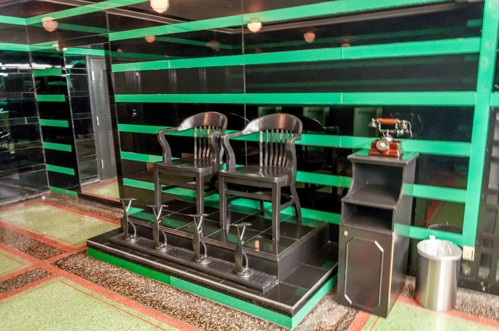Black chairs in front of black and green wall 