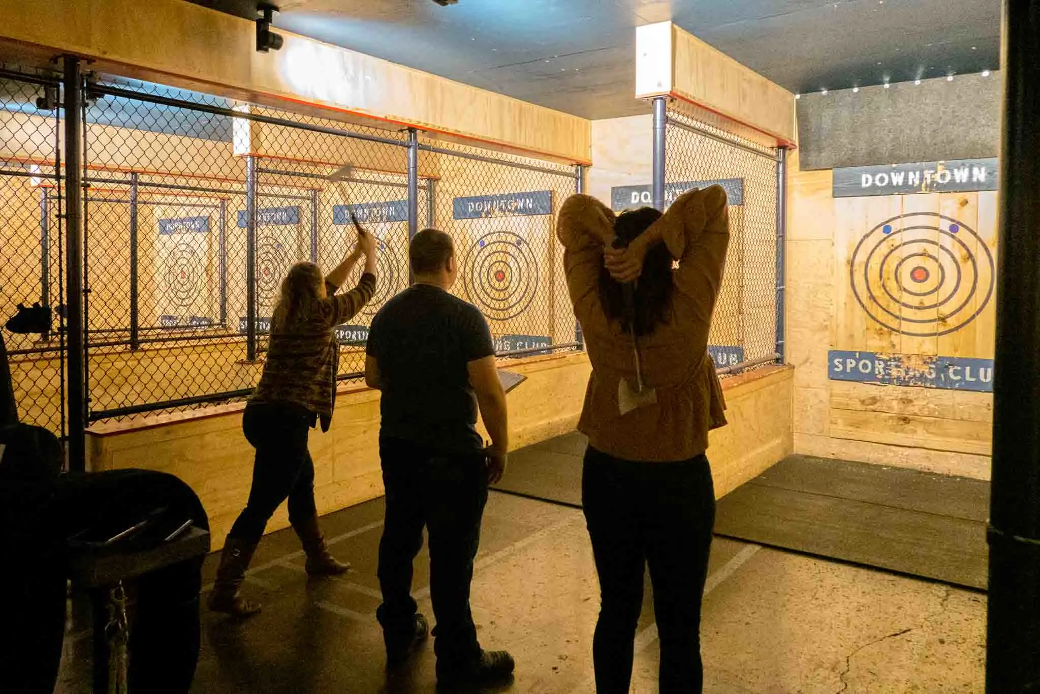 Two people throwing axes at targets on a wall at Downtown Sporting Club in Nashville