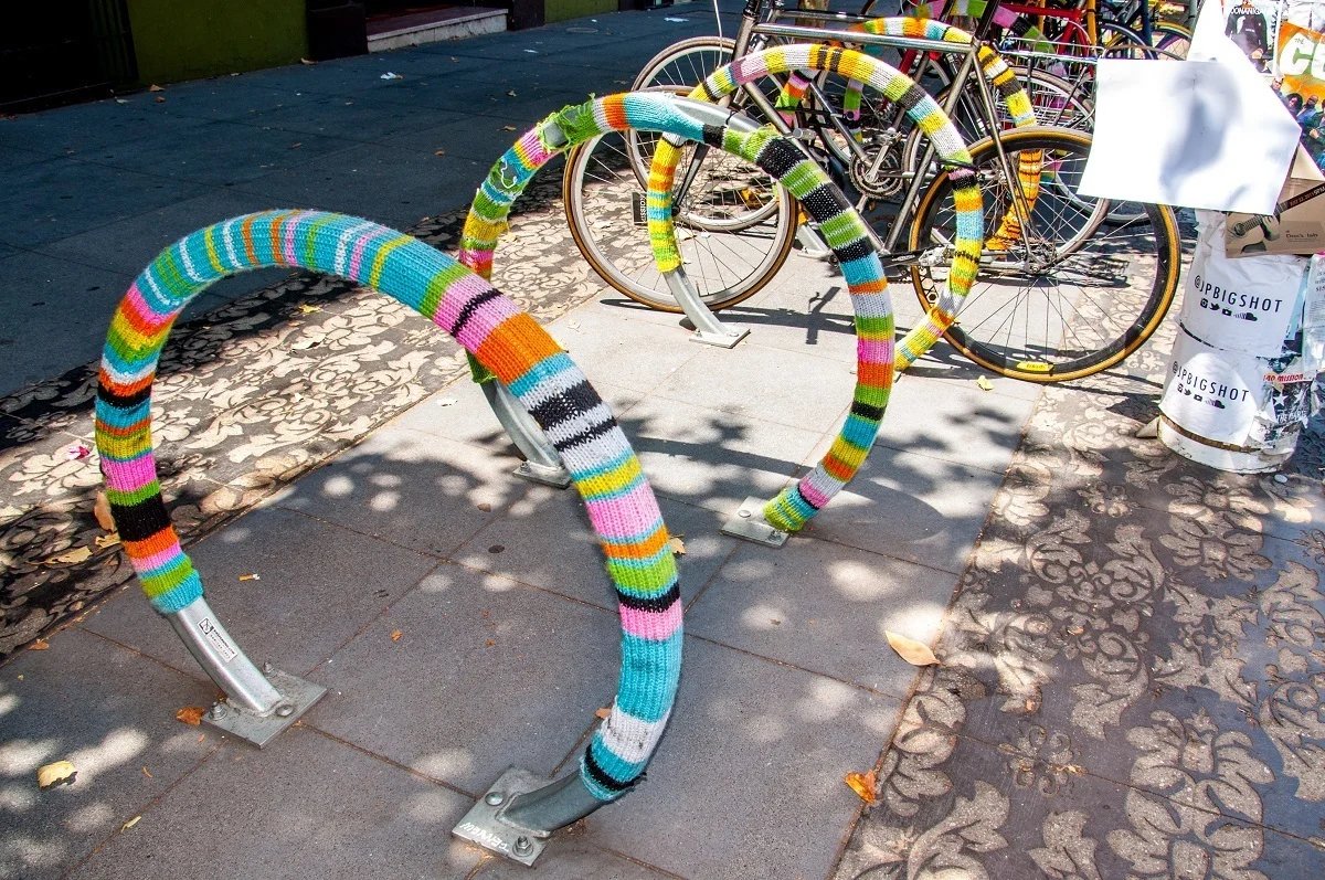 Bike rack covered in multi-colored yarn