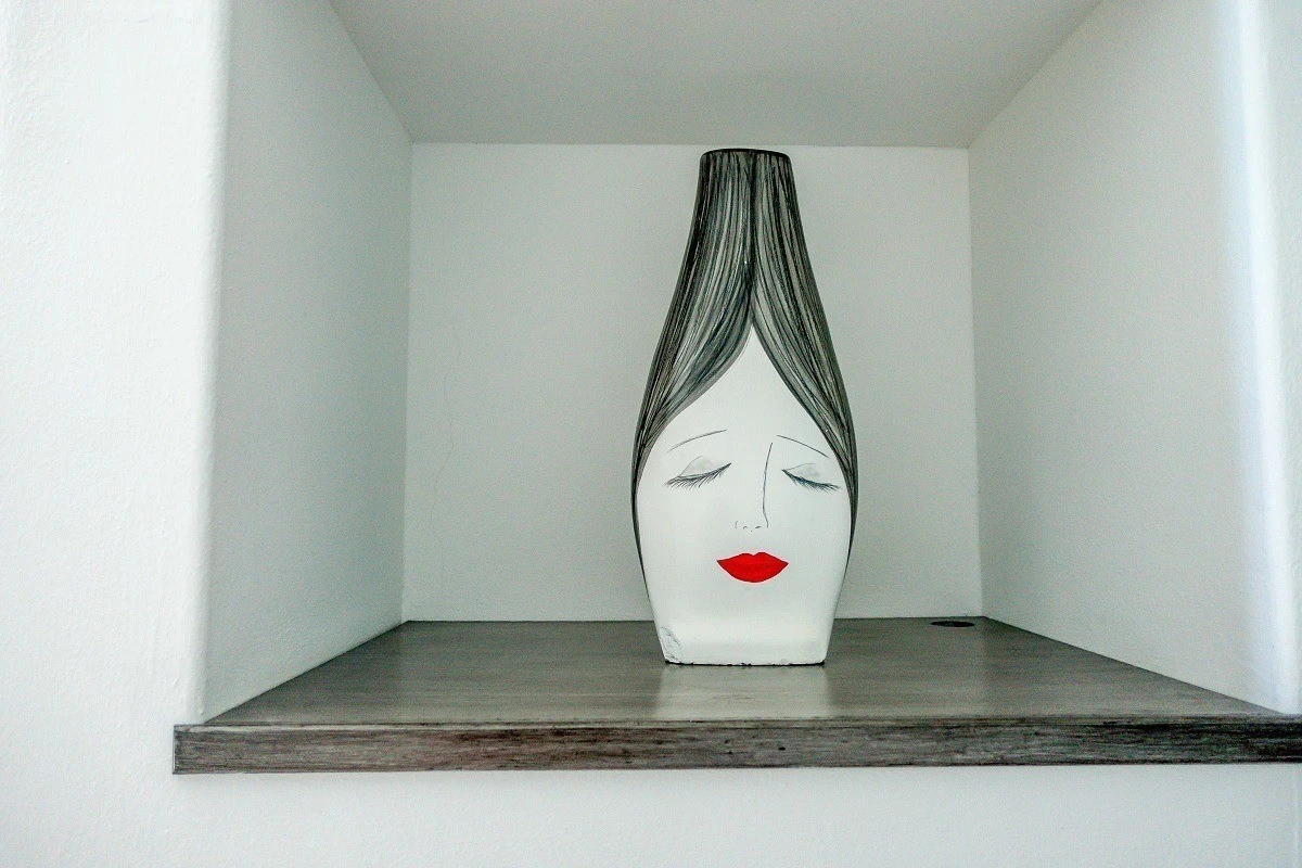 Vase painted with a womans face in the hotel room