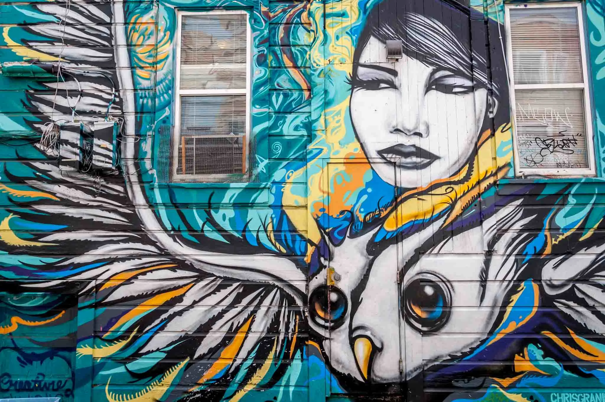 Street art mural of a woman and bird. 