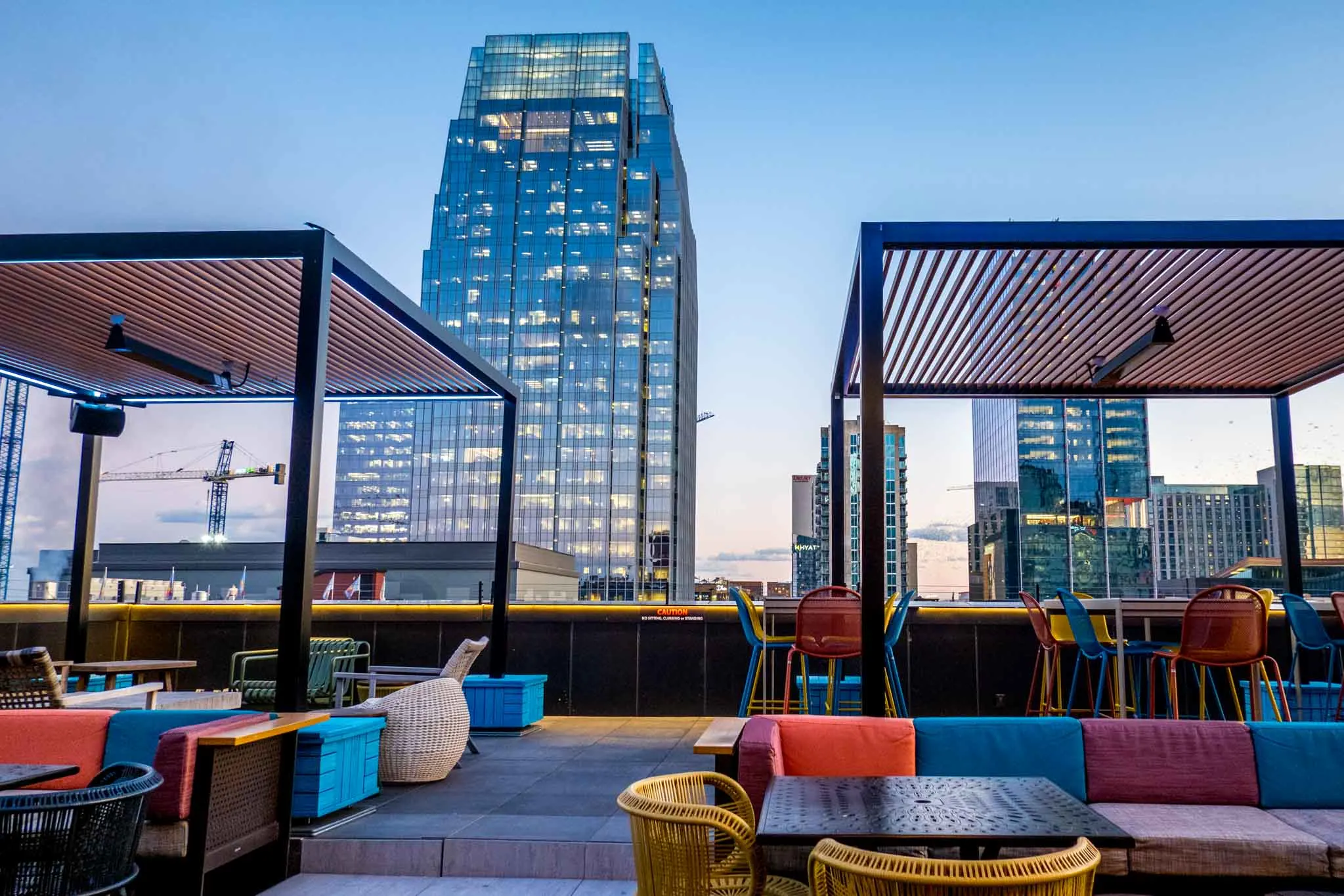 Rooftop bar at sunset featuring seats and a view over Broadway.