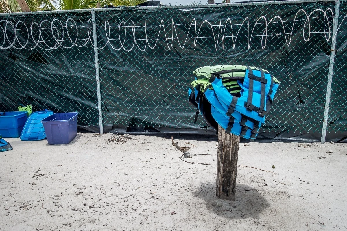 Life jackets drying on top of a wooden post