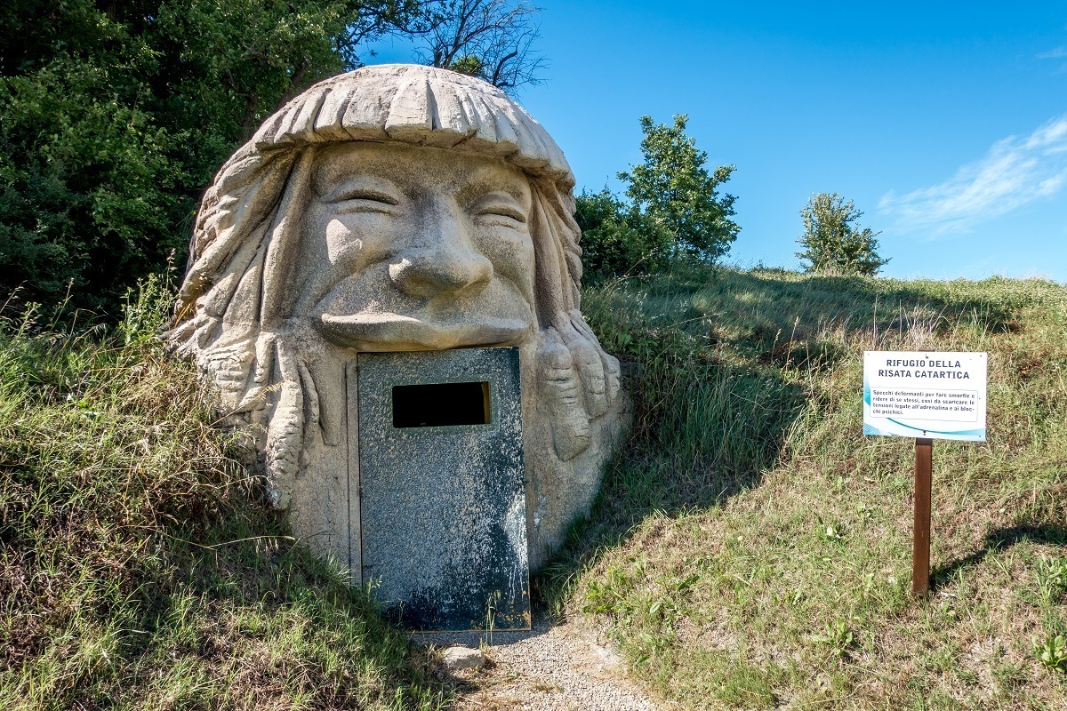 Building shaped like the head of a laughing man with a door as the mouth