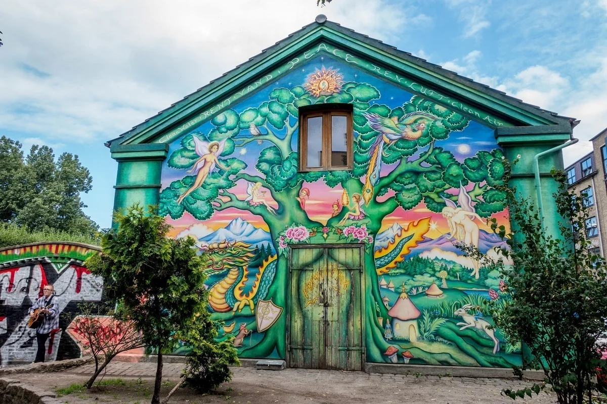 Mural of tree and fairies at the entrance to Freetown Christiania in Copenhagen Denmark