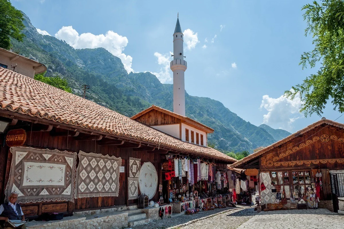 Vendor stalls in Ottoman bazaar with mosque minaret in the background