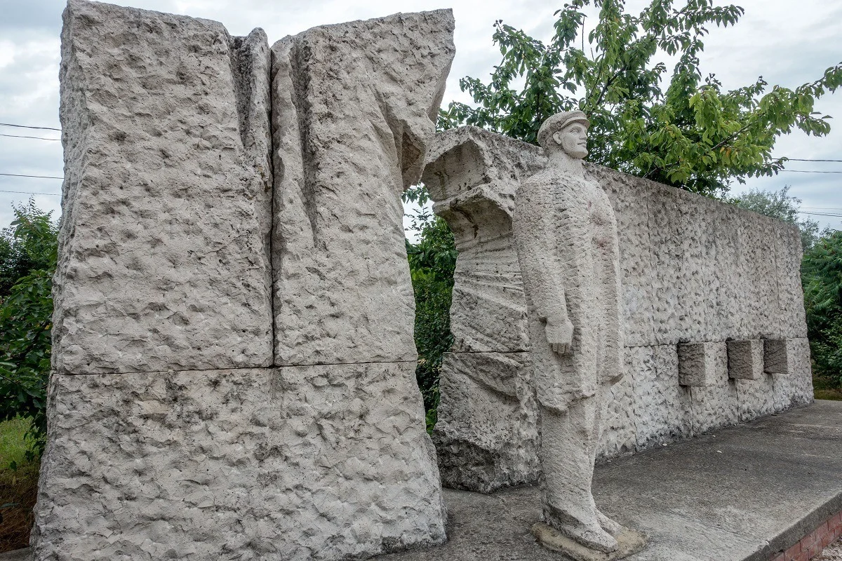 Sculpture of a worker breaking through a wall 