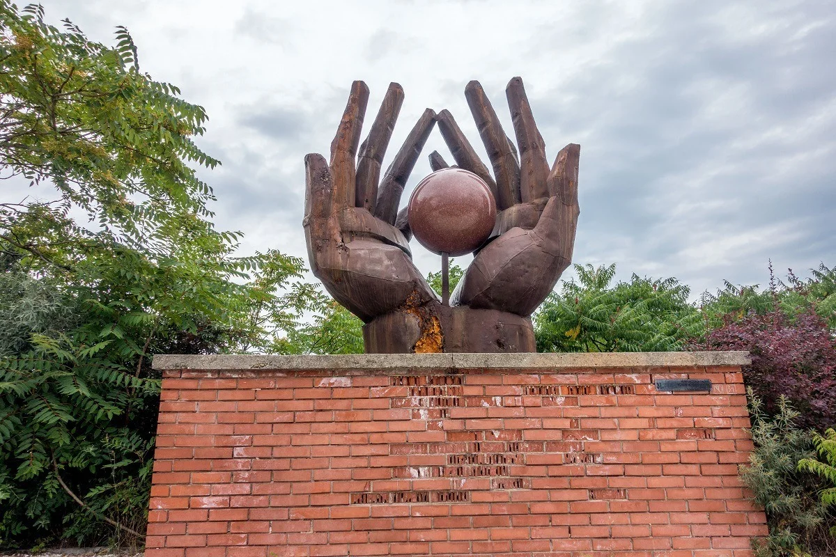 Sculpture of two hands holding a sphere