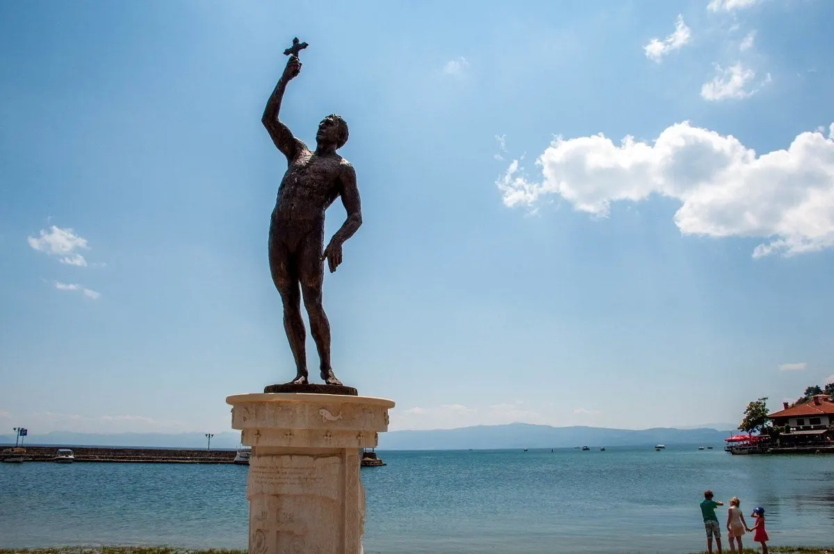 Statue on the shore of Lake Ohrid of man holding a cross
