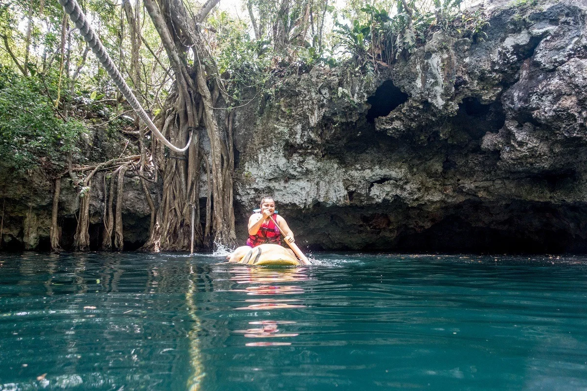 Woman paddling on a kayak in an open cenote in Mexico