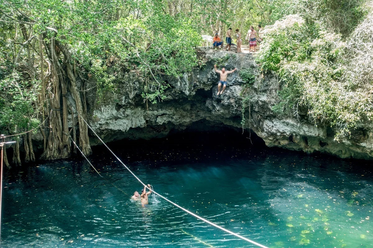 People cliff jumping at the Cenote Verde Lucero into the water below