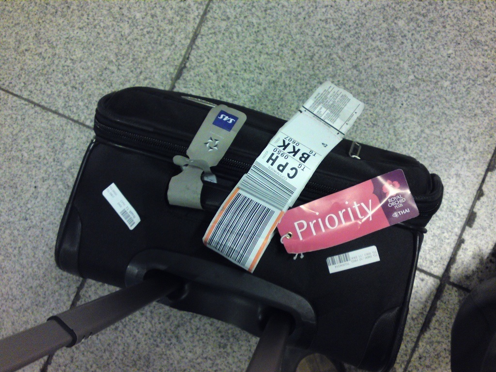 Suitcase with a barcode luggage tracker and bag tags