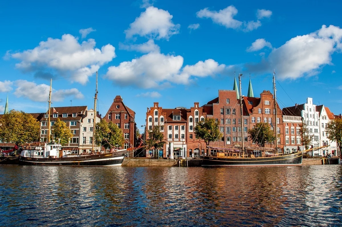 Boats in the Trave River and historic buildings in Lubeck Germany