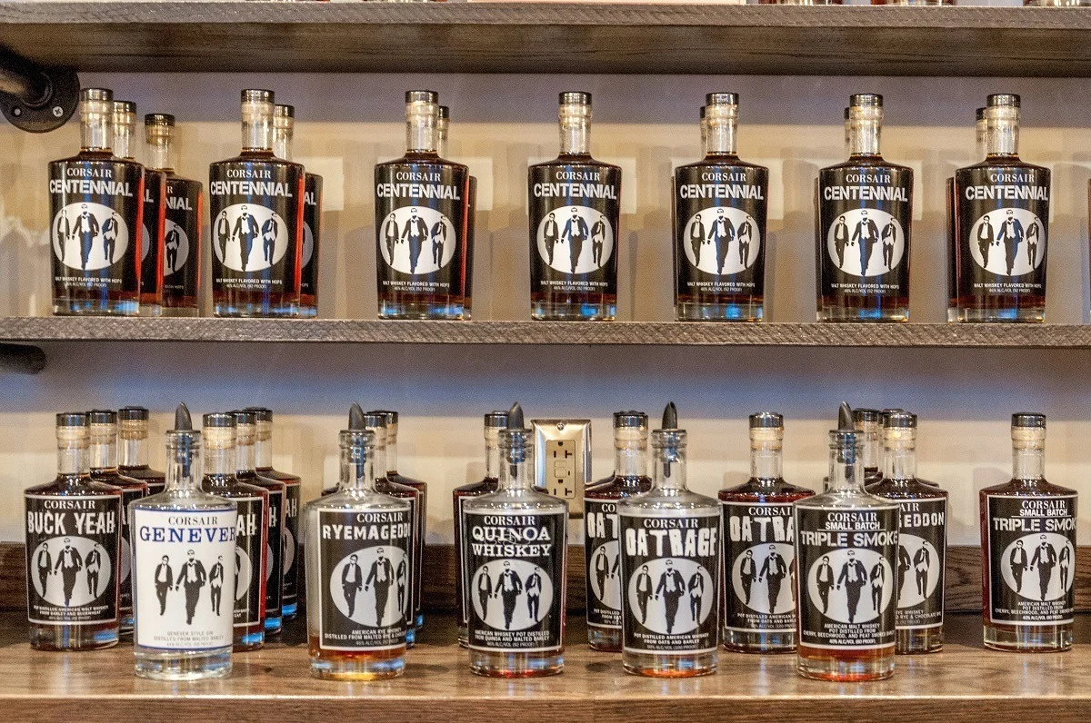 Shelf lined with bottles of whiskey at Corsair Distillery