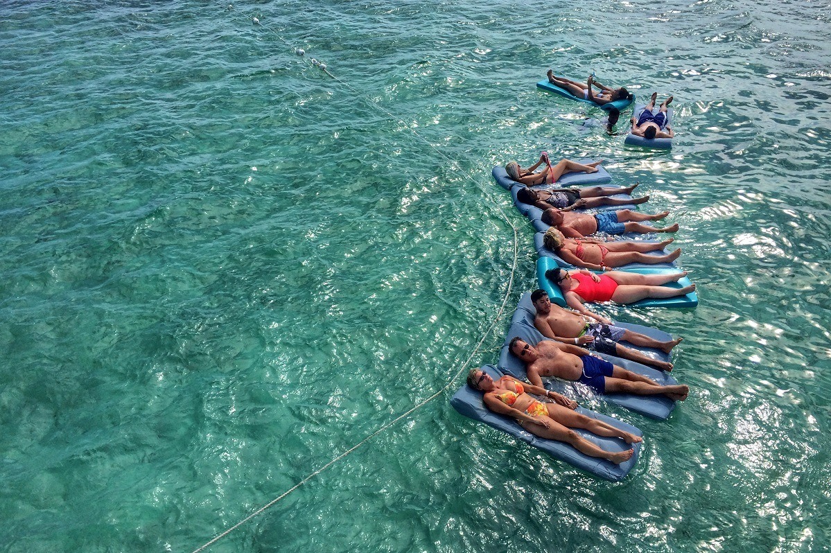 Line of people floating on mats in the ocean