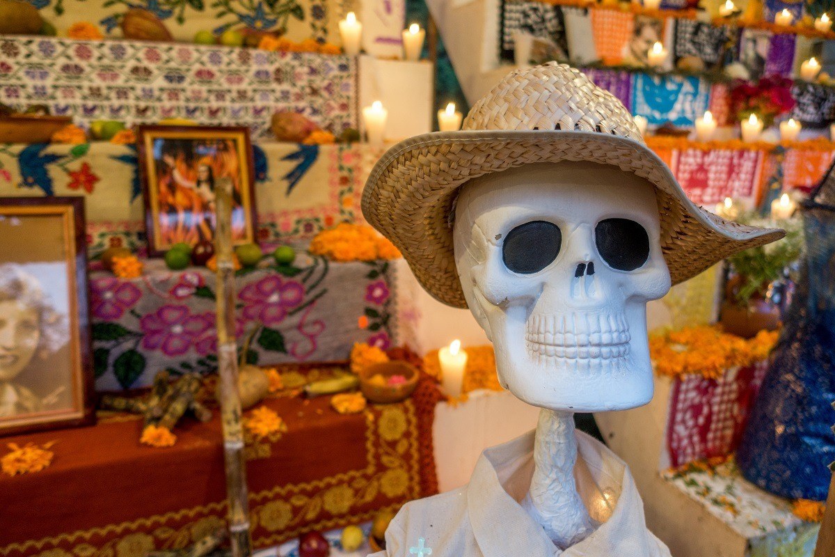 Fake skeleton in front of an altar with candles