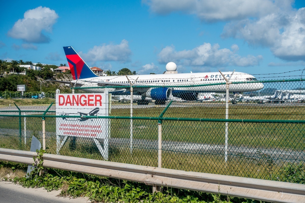 Plane behind a sign about the dangers of being too close 