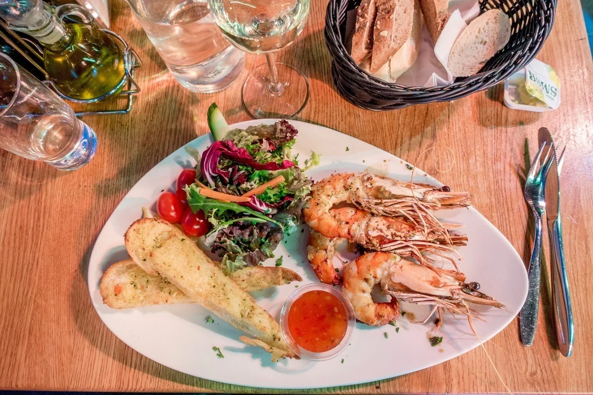 Shrimp, bread, and salad on a plate