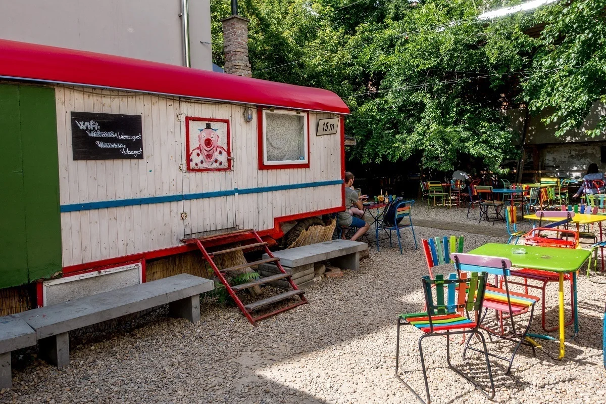 Colorful tables at an outdoor bar with a trailer